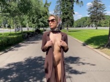 Señora con estilo camina desnuda en el parque. Público.